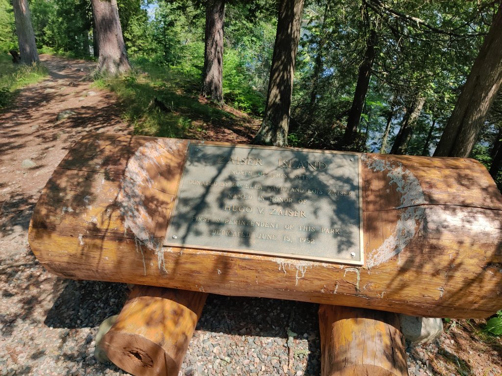Wooden memorial with plaque on Chase Point Trail at Scenic State Park in Bigfork, MN